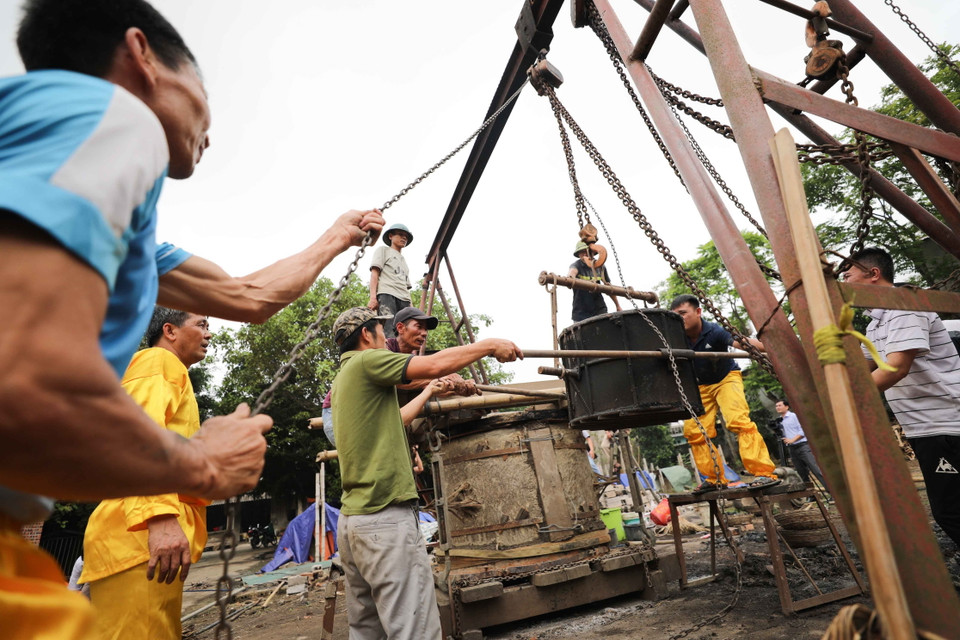 Đồng đã nấu chảy được kéo lên cao để rót vào khuôn. (Ảnh: Thanh Tùng/TTXVN)