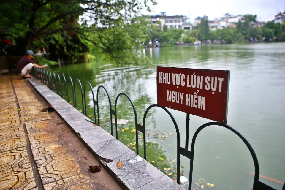 Nhiều điểm sụt lún khu vực bờ kè quanh hồ đã được chính quyền cho dựng rào sắt.(Ảnh: Minh Quyết/TTXVN)