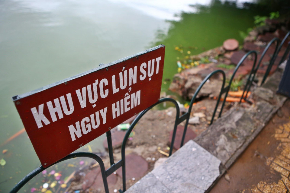 Nhiều điểm sụt lún khu vực bờ kè quanh hồ đã được chính quyền cho dựng rào sắt. (Ảnh: Minh Quyết/TTXVN)