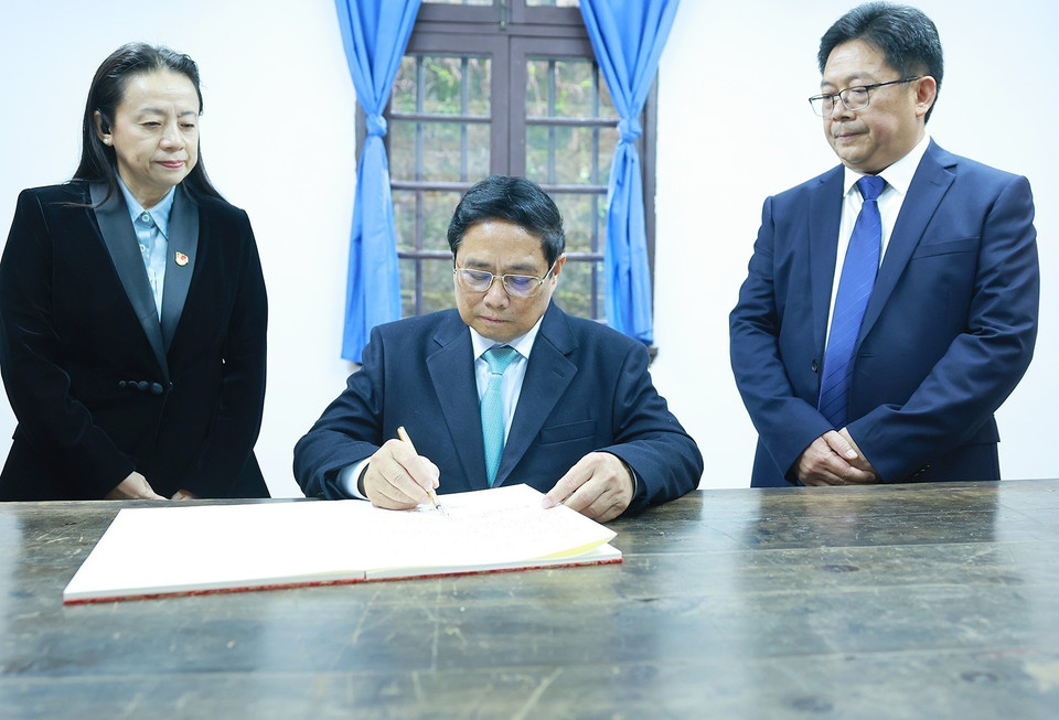 Thủ tướng Phạm Minh Chính viết lưu bút khi đến thăm Khu Di tích lịch sử Hồng Nham. (Ảnh: Dương Giang/TTXVN)