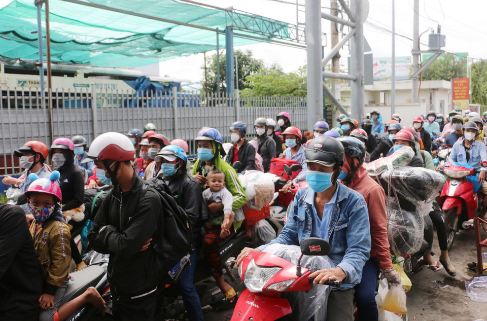 Số lượng người dân về quê tự phát nối hàng dài chờ được cho qua chốt kiểm soát dịch bệnh T2 của thành phố Long Xuyên để thực hiện cách ly tập trung gây ách tắc giao thông cục bộ tại cửa ngõ vào An Giang. (Ảnh: Công Mạo/TTXVN)