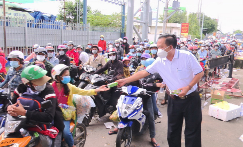 Lực lượng chức năng tỉnh An Giang hỗ trợ đồ ăn, nước uống, sữa cho người dân tại chốt kiểm soát dịch bệnh T2 của thành phố Long Xuyên gây ách tắc giao thông. (Ảnh: Công Mạo/TTXVN)