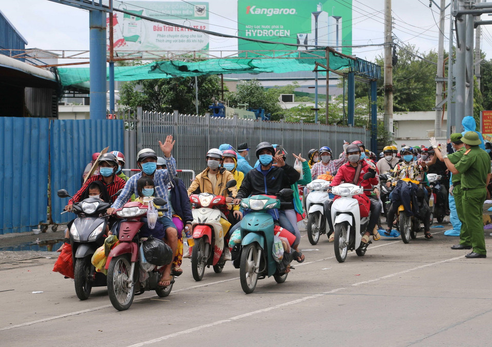 Người dân vui mừng vì được tỉnh An Giang tiếp nhận và đưa về các khu cách ly tạm thời, chờ sàng lọc, phân loại theo từng nhóm đối tượng, địa bàn cư trú sẽ được trước khi bàn giao cho các địa phương đón về cách ly tập trung theo quy định.(Ảnh: Công Mạo/TTXVN)