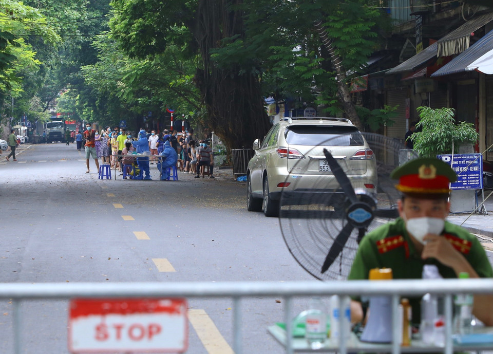 Lực lượng y tế lấy mẫu xét nghiệm cho người dân trên phố Phủ Doãn sáng 3/10. (Ảnh: Hải Anh/TTXVN)