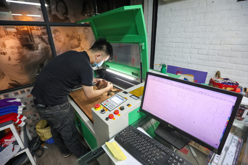 Từ mẫu da lộn nguyên liệu, các chi tiết được cắt laze theo bản vẽ thiết kế và được khâu đột một cách tỉ mỉ, chắc chắn. (Ảnh: Minh Hiếu/Vietnam+)