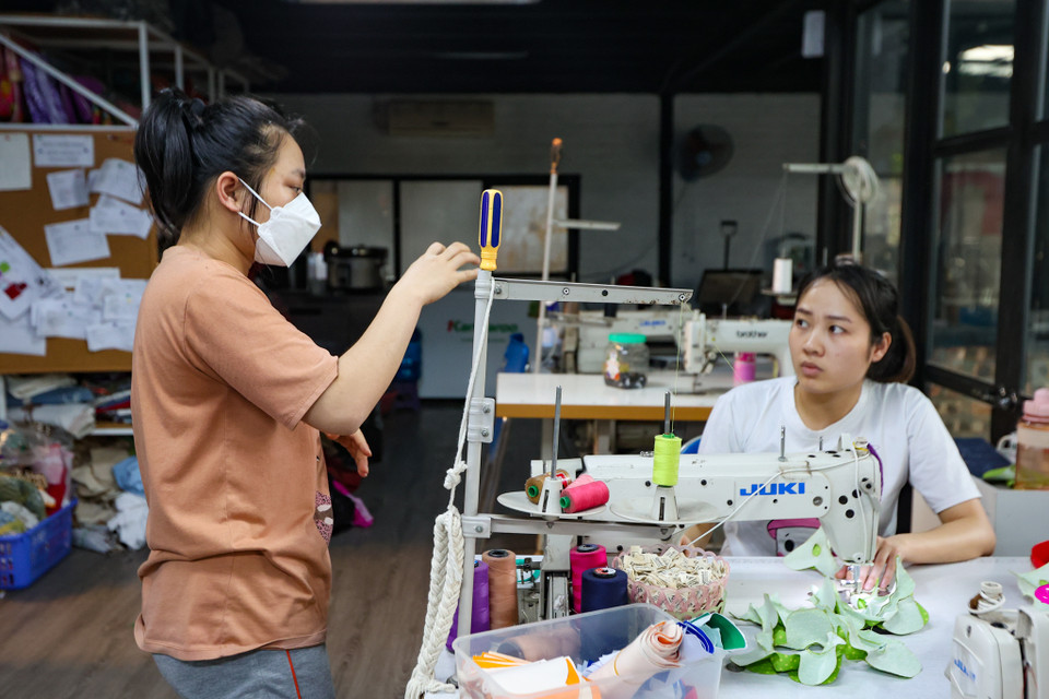 Nhân viên đang trao đổi với nhau trong các khâu làm việc qua cử chỉ tay. (Ảnh: Minh Hiếu/Vietnam+)