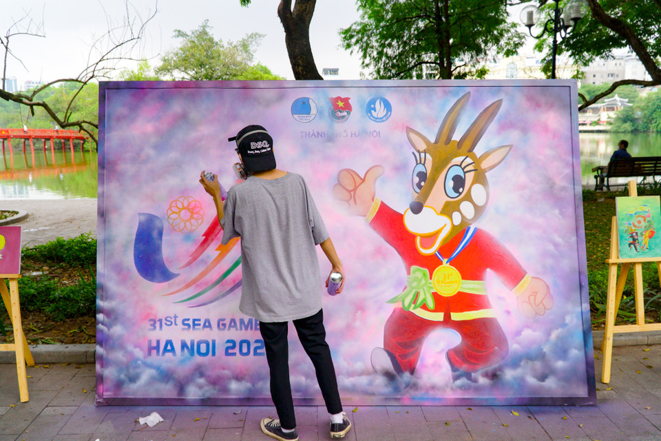 Bạn Trịnh Hùng Tân, Chủ nhiệm Câu lạc bộ Spray Paint Art trường Đại học kiến trúc đang thực hiện bức tranh xịt grafiti cổ động SEA Games 31. (Ảnh: Minh Hiếu/Vietnam+)