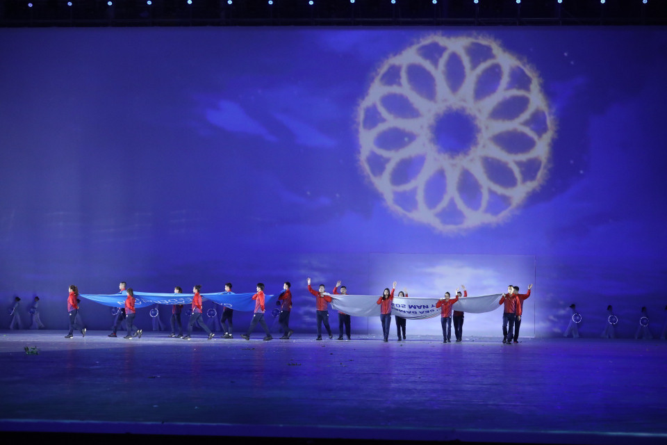 Các VĐV tiêu biểu rước cờ Liên đoàn thể thao Đông Nam Á và cờ SEA Games. (Ảnh: TTXVN)