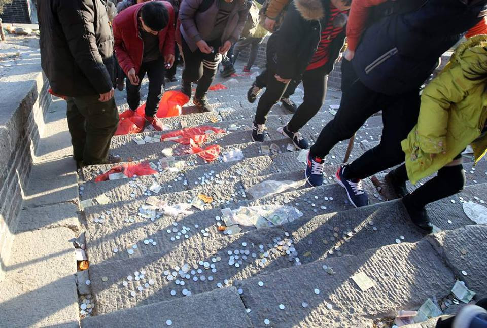 Tuy nhiên, việc trở thành người đầu tiên không phải là chuyện dễ dàng. Ngoài việc thắp hương, người dân cũng tung tiền xu trên đường lên núi để cầu ước. (Nguồn: CCTV)