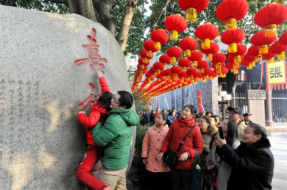 Người dân ở Thành Đô, Tứ Xuyên xếp hàng để chạm tay vào chữ ‘hỷ’ khắc trên đá. (Nguồn: CCTV)