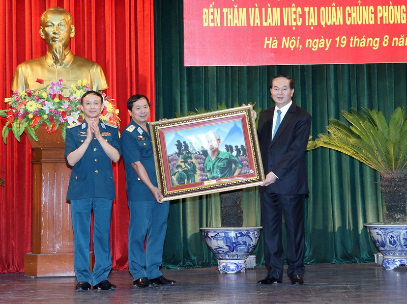 Chủ tịch nước Trần Đại Quang tặng bức tranh 'Bác vẫn cùng chúng cháu hành quân' cho Quân chủng Phòng không-Không quân. (Ảnh: Nhan Sáng/TTXVN)