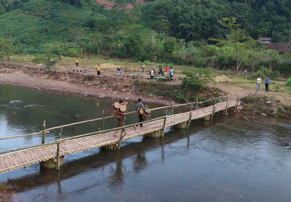 Cây cầu tre bắc qua suối Nậm Bai là con đường dẫn sang bãi đất trống, nơi diễn ra các chương trình gia lưu văn hóa, văn nghệ và thưởng thức ẩm thực ngoài trời khi du khách đến bản Nà Sự. (Ảnh: Xuân Tiến/TTXVN)