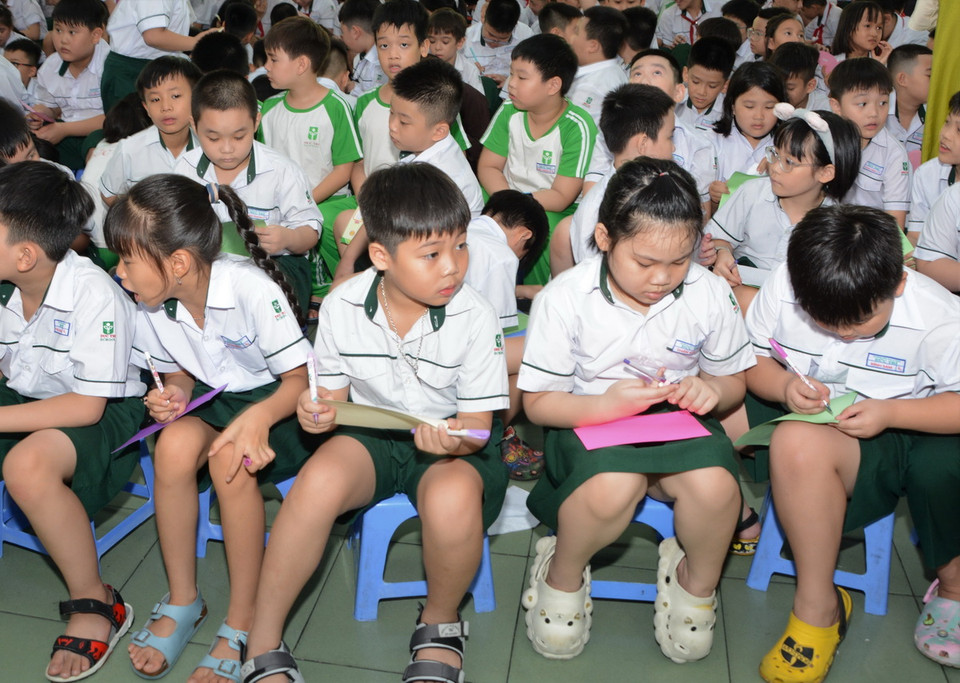 Học sinh trường Mầm non - Tiểu học và Trung học cơ sở Đức Trí (thành phố Đà Nẵng) viết những bức thư gửi gắm tình cảm, động viên đến học sinh bị ảnh hưởng bởi thiên tai. (Ảnh: Văn Dũng/TTXVN)