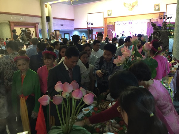 Các bạn bè quốc tế tìm hiểu những món ăn truyền thống của Việt Nam như nem cuốn, chả giò, bánh bột lọc, chè ngô... được giới thiệu tại Đêm hội ASEAN 2015. (Ảnh: Hải-Bình/Vietnam+)