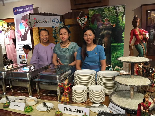 Các cán bộ Sứ quán Thái Lan tươi cười chào đón các bạn bè ASEAN đến với gian hàng ẩm thực của mình tại Đêm hội ASEAN 2015. (Ảnh: Hải-Bình/Vietnam+)