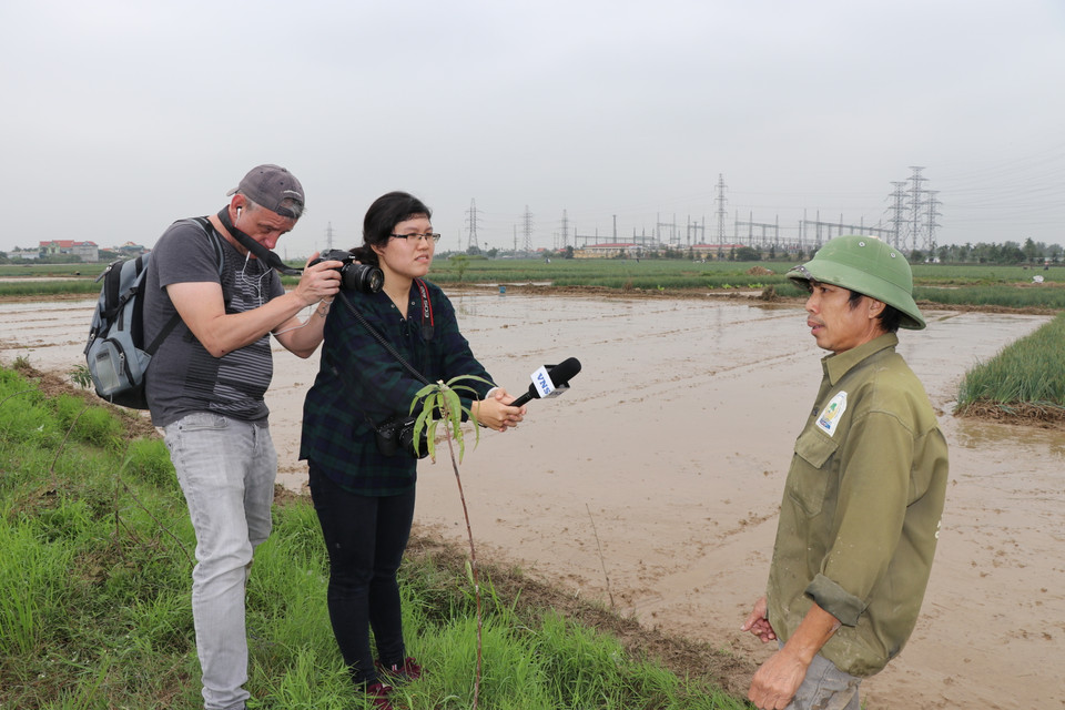 Phóng viên Báo Vietnam News - Thông tấn xã Việt Nam đang phỏng vấn trực tiếp người nông dân tại ruộng hành xã An Phụ. (Ảnh: Hạnh Nguyễn/Vietnam+)