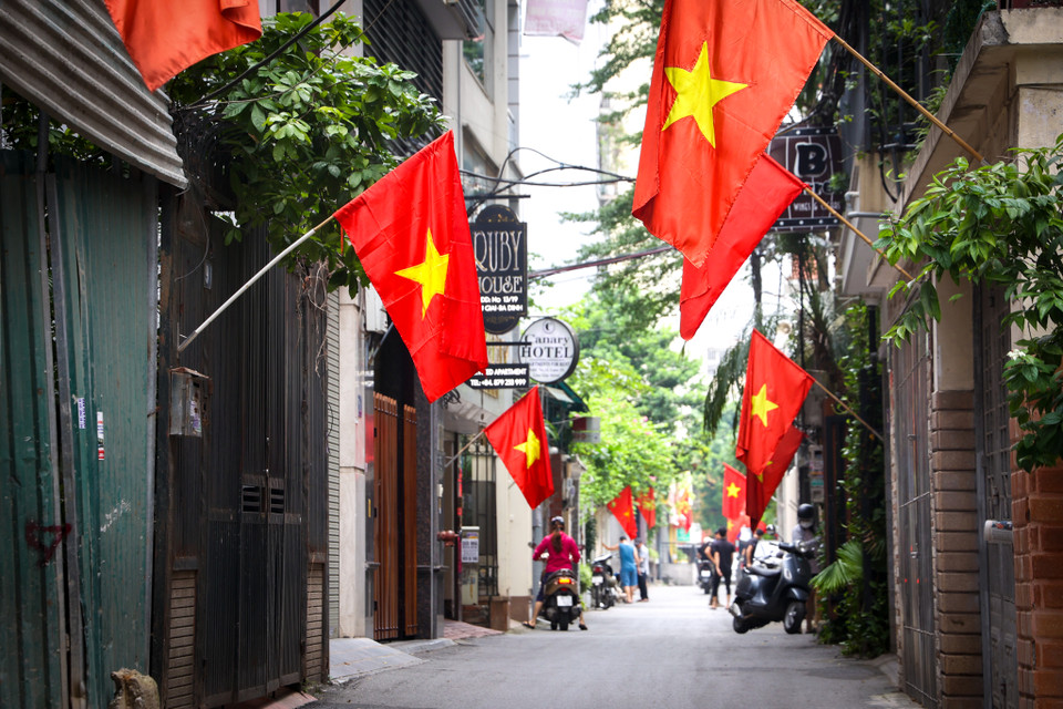Lớp lớp cờ Tổ quốc bay phấp phới trong ngõ nhỏ minh chứng tinh thần yêu nước, sự tự hào và lòng biết ơn của người dân đối với những thế hệ đã hy sinh để bảo vệ, dựng xây nên một Thủ đô hòa bình, giàu đẹp. (Ảnh: Minh Hiếu/Vietnam+)