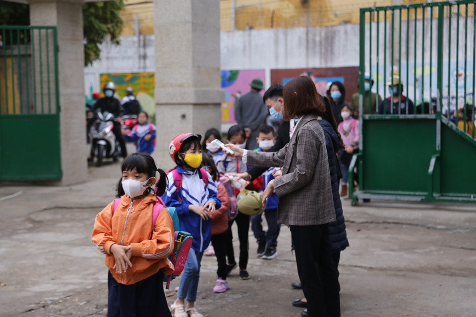 Học sinh trường Tiểu học Sông Đà (tỉnh Hòa Bình) đến trường sáng nay đều được các thầy cô đo thân nhiệt và nhắc nhở các em đeo khẩu trang khi vào trường. (Ảnh: Trọng Đạt/TTXVN) 