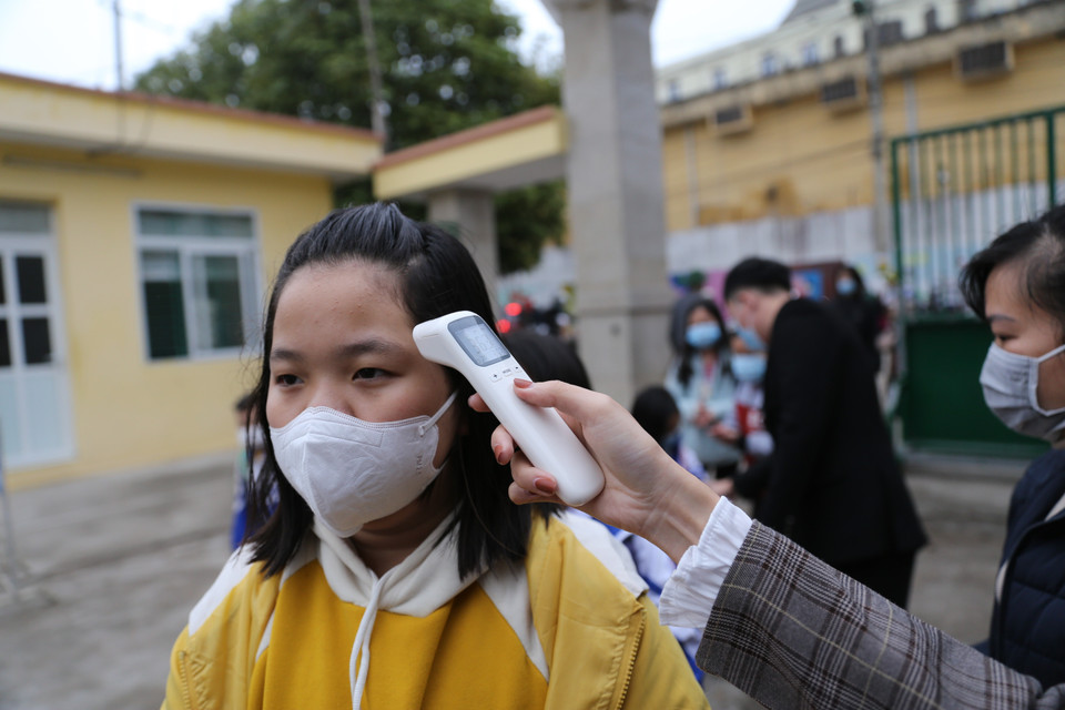 Sáng 1/3, các học sinh trở lại trường ở Hòa Bình đều phải thực hiện nghiêm việc đo thân nhiệt, sát khuẩn tay và đeo khâu trang trước khi vào trường. (Ảnh: Trọng Đạt/TTXVN)