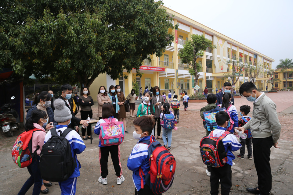Ban Giám hiệu Trường Tiểu học Sông Đà (tỉnh Hòa Bình) cũng như các trường khác trên địa bàn, đã phân công cán bộ, giáo viên thực hiện việc kiểm tra thân nhiệt, đeo khẩu trang và sát khuẩn cho học sinh ngay từ ngoài cổng trường. (Ảnh: Trọng Đạt/TTXVN)