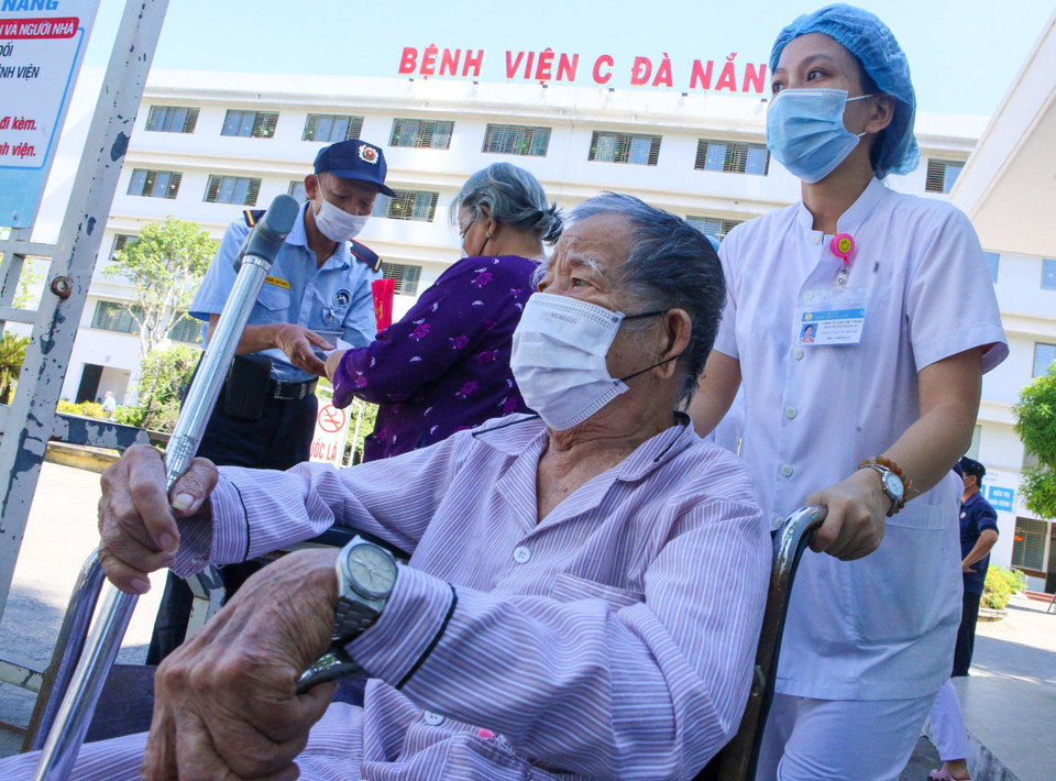 Nhân viên y tế hỗ trợ đưa bệnh nhân ra tận cổng bệnh viện để đảm bảo an toàn các quy định phòng, chống dịch tại bệnh viện. (Ảnh: Trần Lê Lâm/TTXVN)