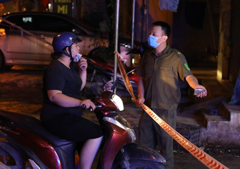 Lực lượng chức năng phong tỏa, kiểm soát các lối ra, vào khu vực tòa nhà bệnh nhân 785 sinh sống. (Ảnh: Văn Điệp/TTXVN)