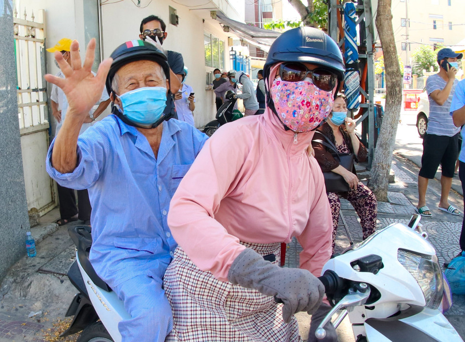 Một cụ ông phấn khởi sau khi hoàn thành đợt điều trị và cách ly tại Bệnh viện C Đà Nẵng được người thân đón về nhà. (Ảnh: Trần Lê Lâm/TTXVN)