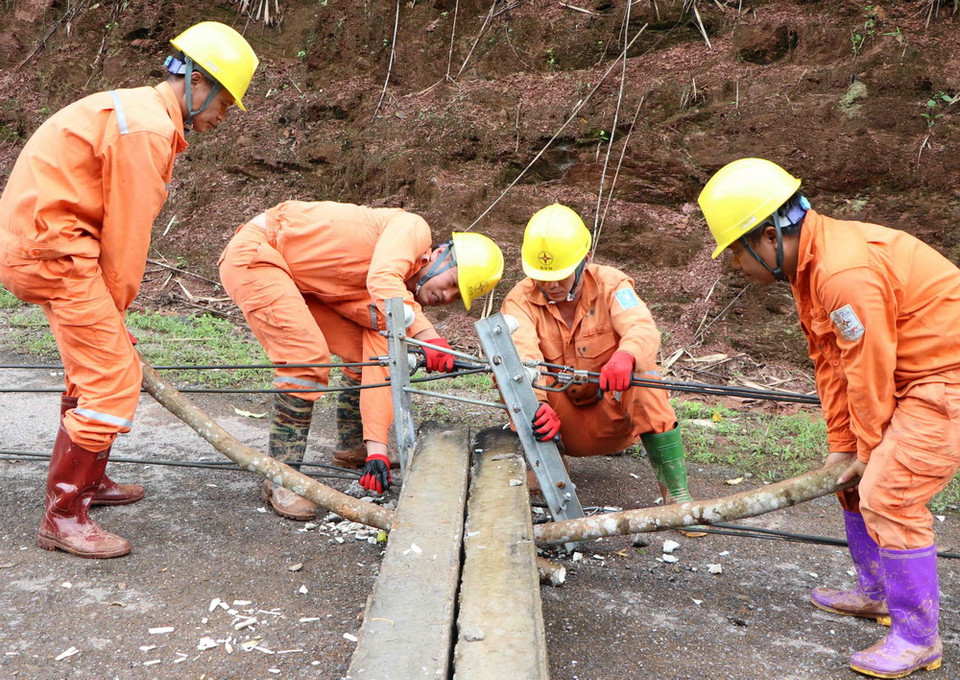 Cán bộ nhân viên kỹ thuật của công ty điện Nậm Nhùn kiểm tra, khắc phục sự cố hệ thống lưới điện bị thiệt hại do mưa lũ gây ra tại bản Gia Tè, xã Mù Cả, huyện Mường Tè (Lai Châu). (Ảnh: Quý Trung/TTXVN)