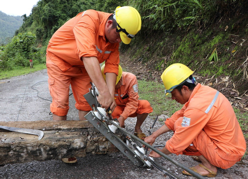 Cán bộ nhân viên kỹ thuật của công ty điện Nậm Nhùn (Mường Tè) kiểm tra, khắc phục sự cố hệ thống lưới điện bị thiệt hại do mưa lũ gây ra tại bản Gia Tè, xã Mù Cả. (Ảnh: Quý Trung/TTXVN)