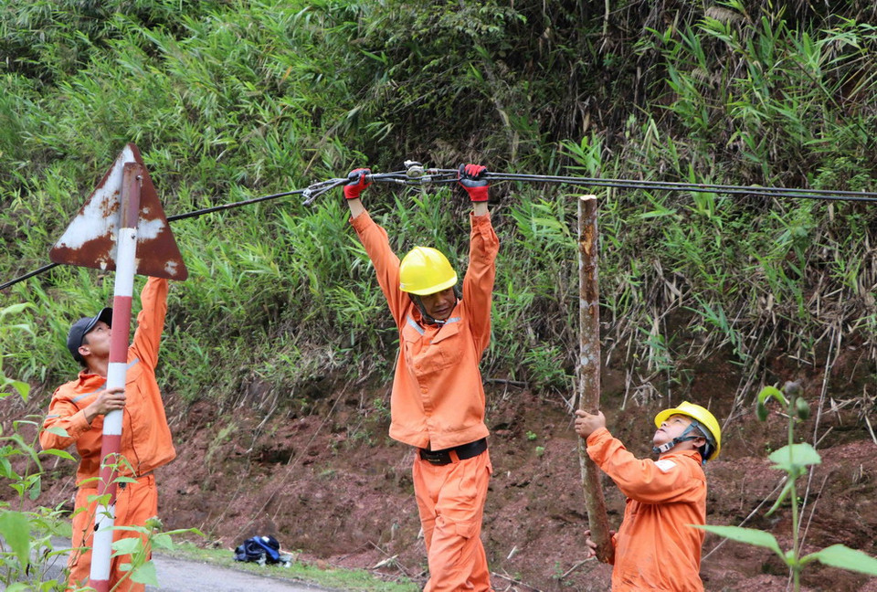 Cán bộ nhân viên kỹ thuật của công ty điện Nậm Nhùn (Mường Tè) kiểm tra, khắc phục sự cố hệ thống lưới điện bị thiệt hại do mưa lũ gây ra tại bản Gia Tè, xã Mù Cả. (Ảnh: Quý Trung/TTXVN)