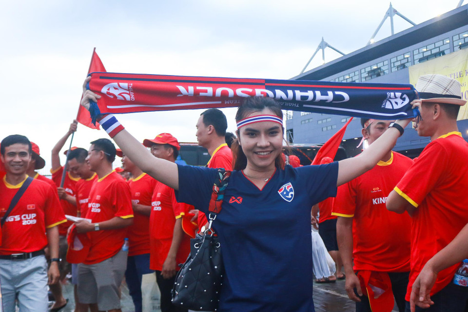 Nữ cổ động viên Thái Lan hòa mình vào người hâm mộ áo đỏ của Việt Nam. (Ảnh: Nguyên An/Vietnam+)