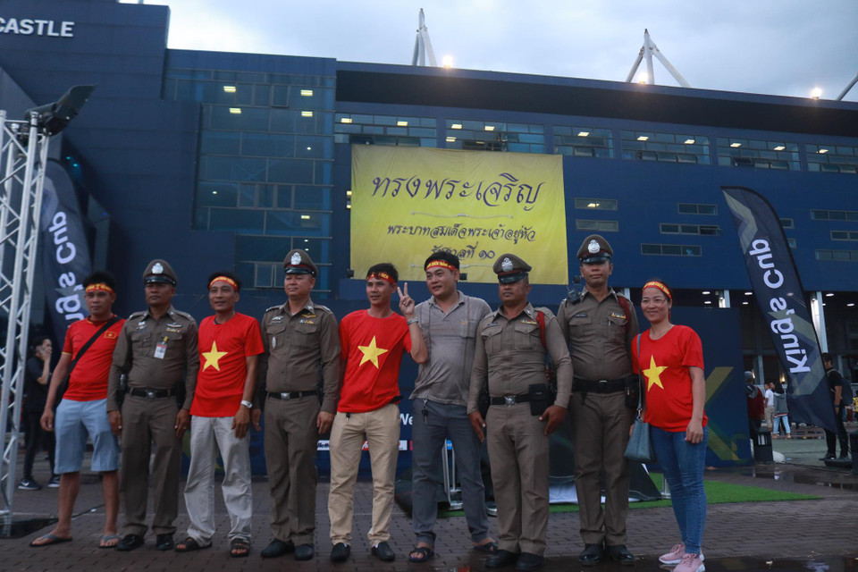 Cổ động viên Việt Nam chụp ảnh lưu niệm cùng cảnh sát Thái Lan trước giờ bóng lăn. (Ảnh: Nguyên An/Vietnam+)