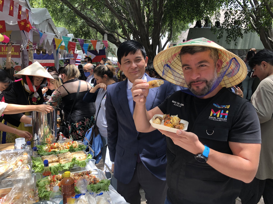 Chủ tịch quận Mauricio Tabe Echartea thưởng thức món nem rán của Việt Nam. (Ảnh: Lưu Việt Hùng/TTXVN)