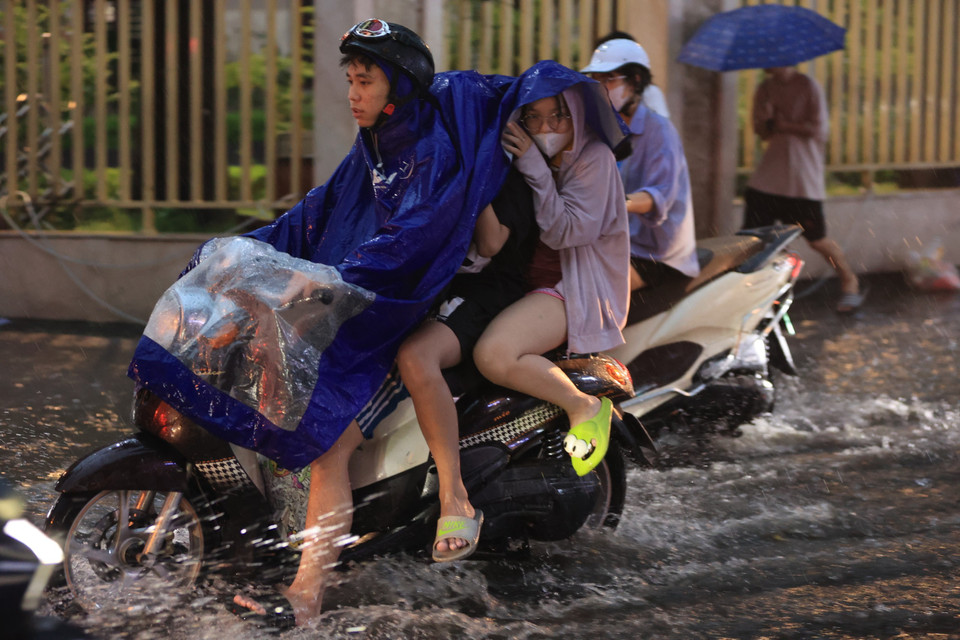 Ngập sâu khiến người dân di chuyển khó khăn. (Ảnh: Hoài Nam/Vietnam+)