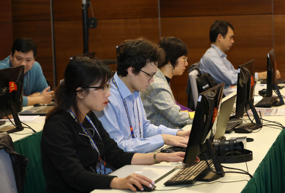 Phóng viên báo chí quốc tế tác nghiệp tại Trung tâm Báo chí Đại hội XIII của Đảng. (Ảnh: TTXVN)