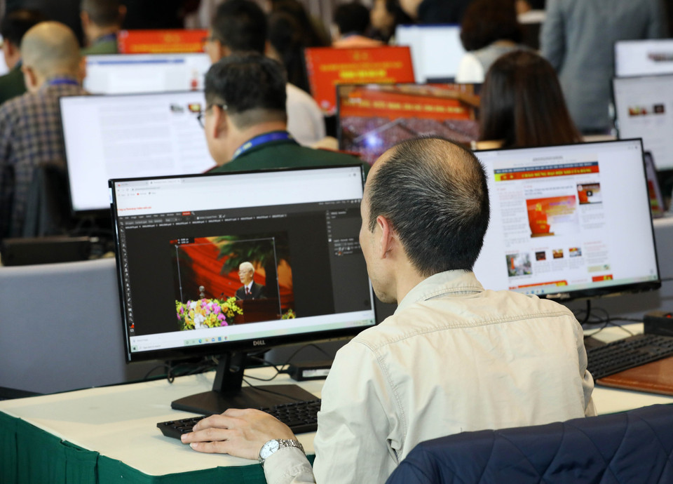 Phóng viên cơ quan báo chí trong nước tác nghiệp tại Trung tâm Báo chí Đại hội XIII của Đảng. (Ảnh: TTXVN)