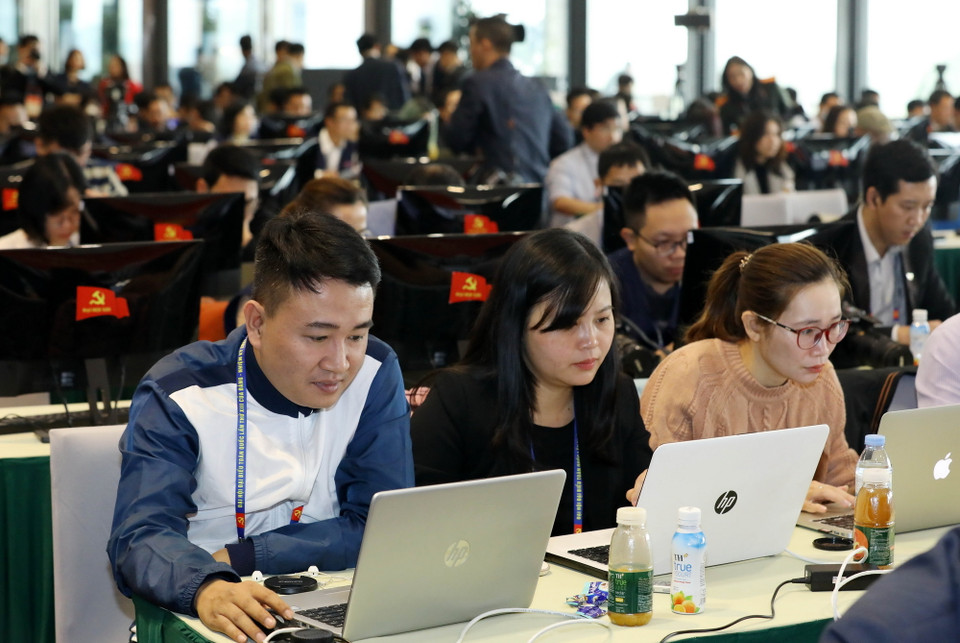 Phóng viên các cơ quan thông tấn, báo chí trong nước tác nghiệp tại Trung tâm Báo chí Đại hội XIII của Đảng. (Ảnh: TTXVN)