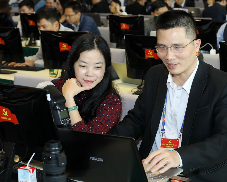 Phóng viên các cơ quan thông tấn, báo chí trong nước tác nghiệp tại Trung tâm Báo chí Đại hội XIII của Đảng. (Ảnh: TTXVN)