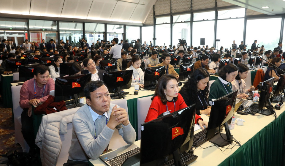 Phóng viên các cơ quan thông tấn, báo chí trong nước tác nghiệp tại Trung tâm Báo chí Đại hội XIII của Đảng. (Ảnh: TTXVN)