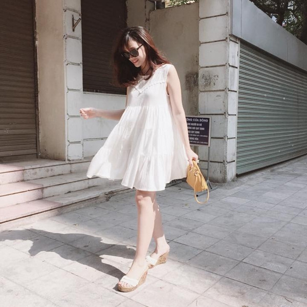 Ngọc Mon cũng diện một thiết kế đầm trắng dáng babydoll (búp bê) xuống phố ngày nắng đẹp. Cô nàng 'mix' cùng sandals đế cói và túi cỡ nhỏ xinh xắn. (Đầm của Chamo Samo).