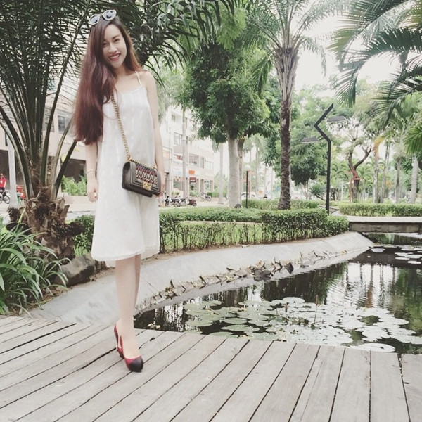 Moonie duyên dáng trong slip-dress trắng và giày cao gót cổ điển. Phụ kiện đắt giá là chiếc túi đeo chéo cỡ nhỏ làm nên điểm cộng cho tổng thể trang phục. (Đầm Ren by Tee).