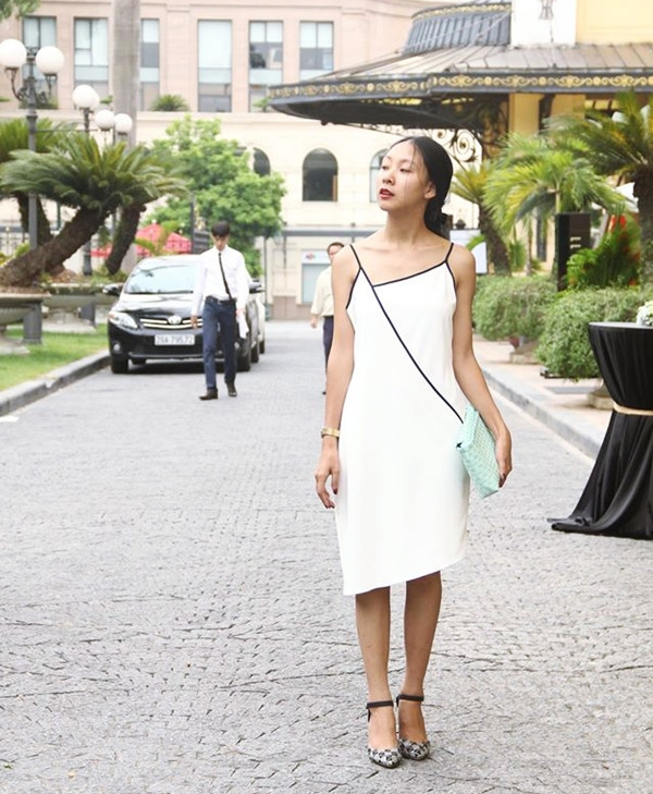 Cô nàng Tracy Đặng - 'chủ xị' trang blog Dear Ladies - duyên dáng trong thiết kế slip-dress (đầm hai dây) bất đối xứng lạ mắt, kết hợp cùng ví cầm tay đan thủ công mang gam màu xanh bạc hà mát rượi (đầm Cosmo Design: 496.000VND - ví cầm tay Ladan).