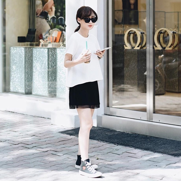 Sun Ht thoải mái trong set đồ đen - trắng đơn giản gồm áo phông và chân váy phối cùng giày thể thao cổ cao. (Áo Sunnie's Wardrobe: 325.000VND - chân váy: 315.000VND). 