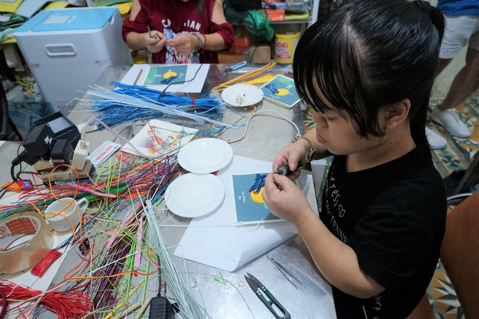 Những tấm thiệp là tác phẩm do người khuyết tật có hoàn cảnh đặc biệt tại doanh nghiệp xã hội thiết kế và sản xuất thủ công dành riêng cho hành khách nhí của Vietnam Airlines. (Ảnh: Minh Tuấn/Vietnam+)
