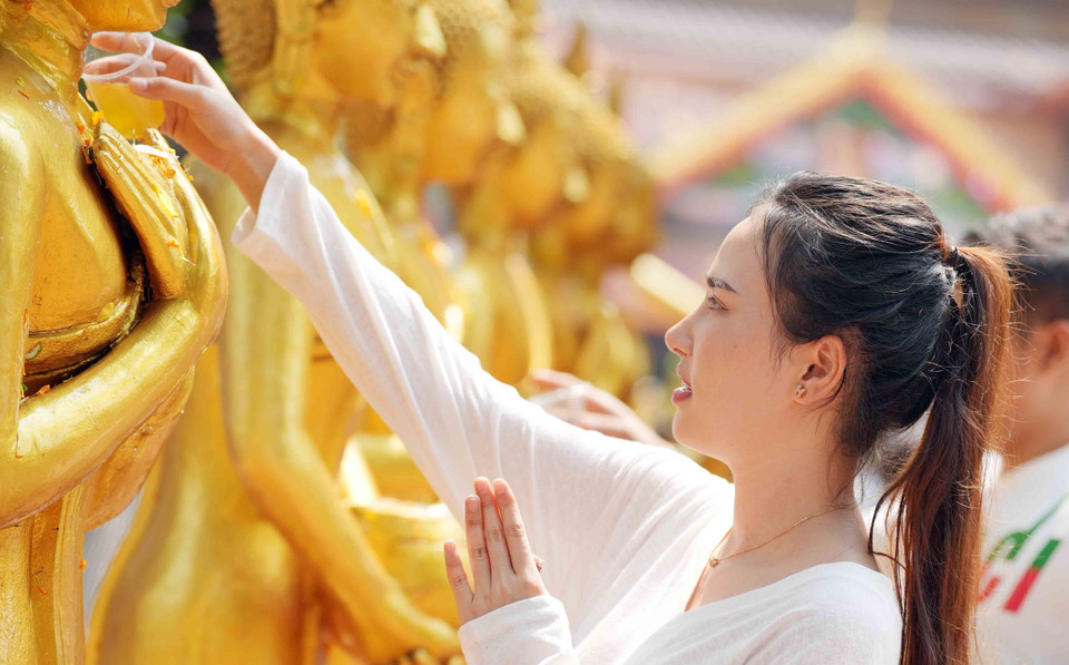 Tắm Phật là một trong những nghi lễ quan trọng và là một hoạt động không thể thiếu trong dịp Tết Bunpimay. (Ảnh: Đỗ Bá Thành/TTXVN)