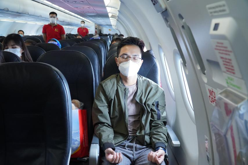 Hành khách trải nghiệm các bài tập yoga ngay trên máy bay. (Ảnh: CTV/Vietnam+)