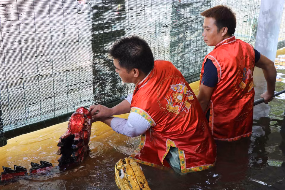 Các nghệ sỹ phường múa rối nước Đồng Ngư, xã Ngũ Thái (Thuận Thành, Bắc Ninh) chuẩn bị đạo cụ cho con rối trước khi biểu diễn. (Ảnh: Diệp Trương/TTXVN)