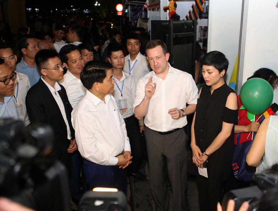 Chủ tịch UBND thành phố Hà Nội Nguyễn Đức Chung cùng các đại biểu tham quan Ngôi làng Châu Âu được tái hiện tại không gian phố đi bộ Hồ Gươm, điểm nhấn của chuỗi sự kiện trong Những ngày châu Âu 2018. (Ảnh: Thanh Tùng/TTXVN)