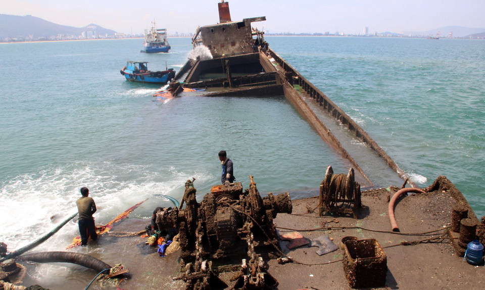 Đơn vị trục vớt dùng vòi rồng bơm nước ra khỏi khoang tàu chìm để làm nổi tàu. (Ảnh: Nguyên Linh/TTXVN)