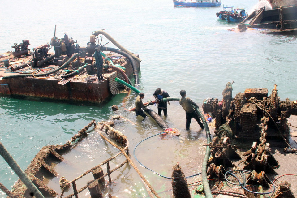 Đơn vị trục vớt dùng vòi rồng bơm nước ra khỏi khoang tàu chìm để làm nổi tàu. (Ảnh: Nguyên Linh/TTXVN)